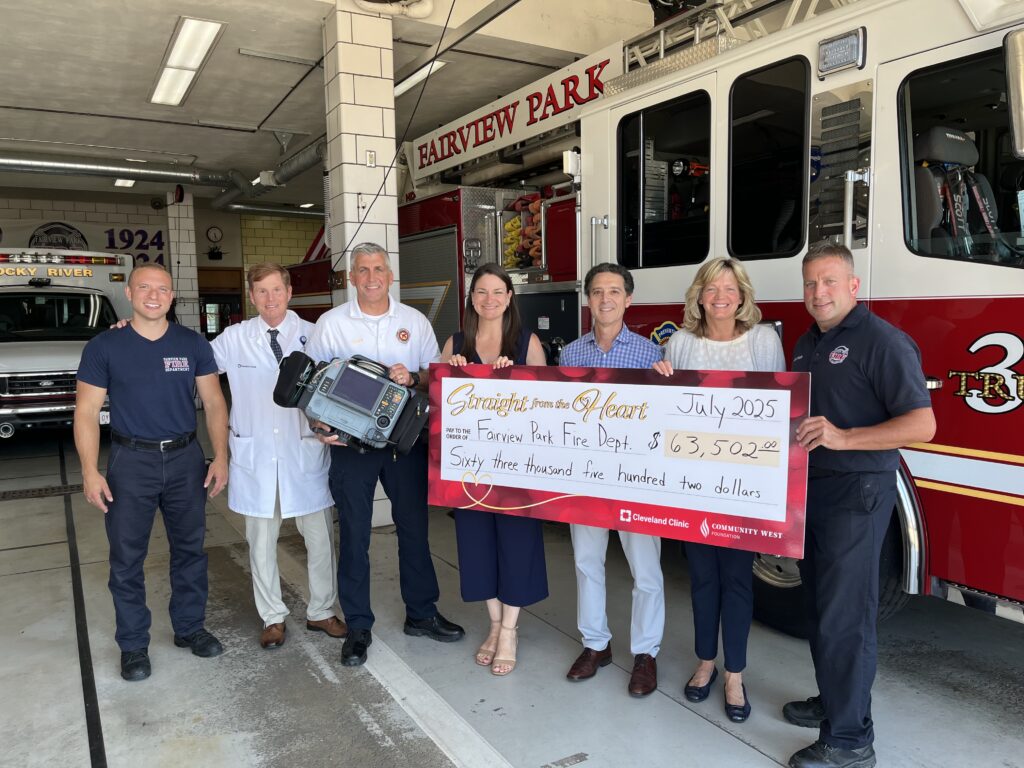 7 people smiling holding a jumbo sized check